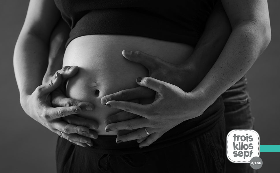 Femme enceinte accompagnée son conjoint pour une séance photo grossesse