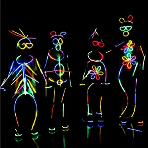 Several kids are standing on a stage wearing glowing accessories, ready for the lights to turn on.