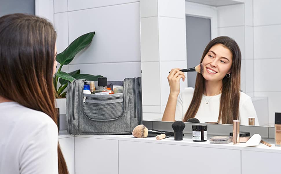 La femme sur le miroir se maquille. Trousse de toilette et accessoires de maquillage.