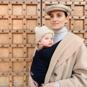 Maman marche avec son fils dans le porte-bébé Koala Babycare noir