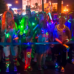 Un groupe de personnes s'amuse à porter des accessoires lumineux de la tête aux pieds.