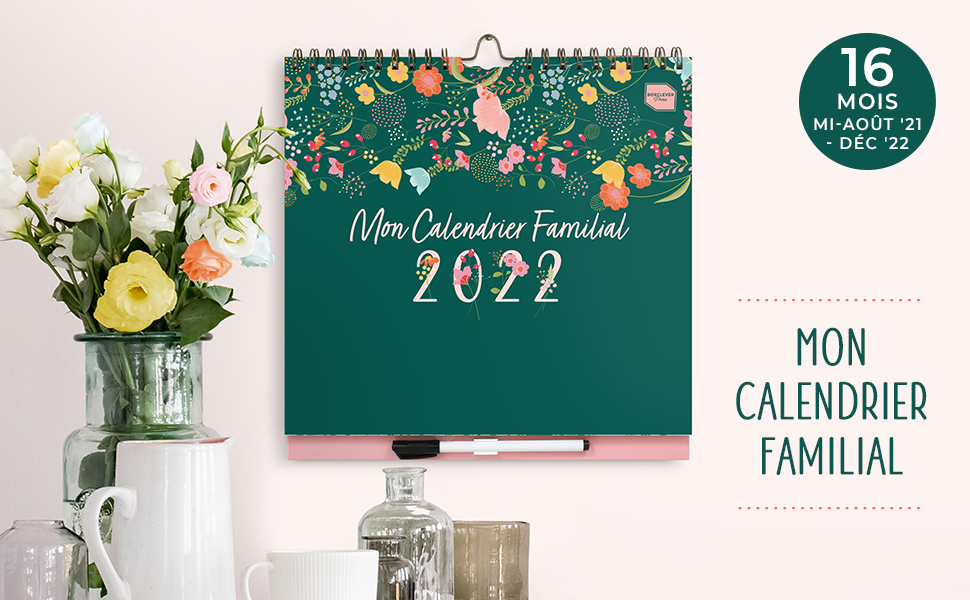 Mon Calendrier Familial sur un mur au-dessus un vase avec des fleurs et un broc